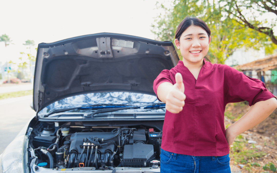 Happy car owner giving a thumbs-up in front of an open hood after vehicle service at Scott's Fort Collins Auto.