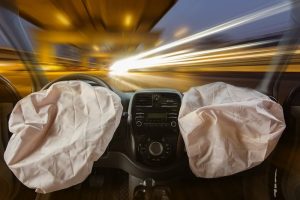 A view of airbags in both the driver and passenger side that have been deployed.