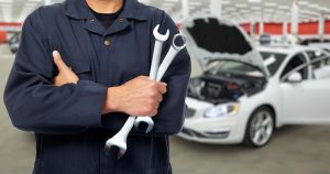 Hands of car mechanic with wrench in auto repair service.