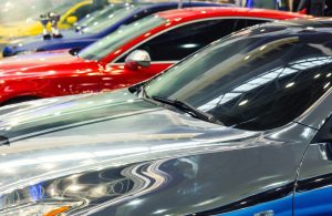 A view of several car hoods that are cars of all different colors. The colors are deeper blue, yellow, silver and red.
