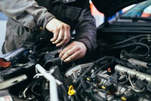 Close-up view of a a car professional working on the engine of a car. 