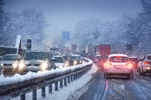 A view of a freeway during the winter packed with driving cars.