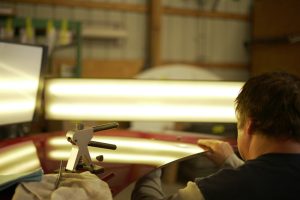 Man working on dents on a car.