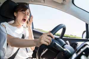 yawning female driver. falling asleep at the wheel concept.