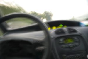 Image of a blurry dashboard and steering wheel.