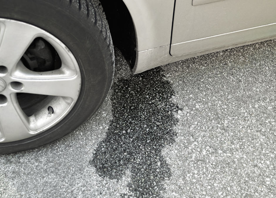 Automotive fluid leak from oil, coolant, or brake on ground from car